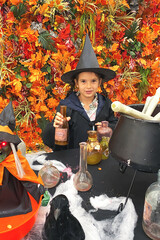 one white girl 6 years old celebrates halloween, brews potion from bones, vertical photo, looks at...