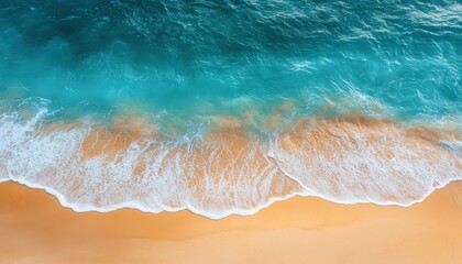 Aerial view of ocean waves crashing on golden sandy beach during a sunny summer day