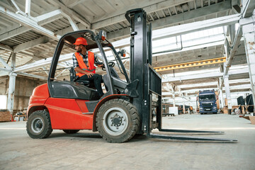 Driving the forklift. Industrial worker in wooden warehouse