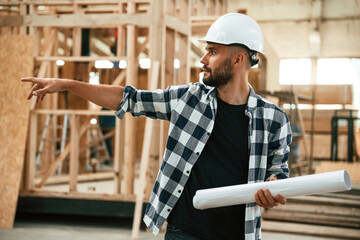 Giving the orders by hand gesture. Industrial worker in wooden warehouse