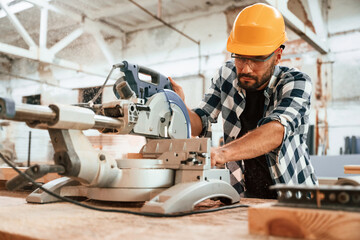 Focused, woodworking. Man is in warehouse