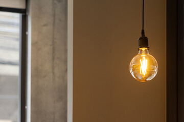 A vintage light bulb hanging from a ceiling.