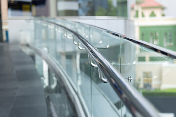 A glass railing with a view of a building in the background