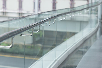 A glass railing with a metal bar on it