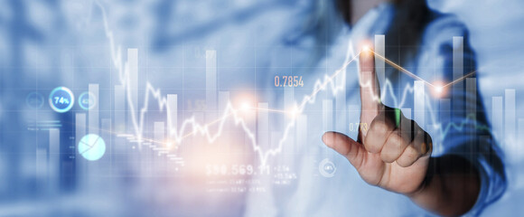 Business person pointing growing virtual hologram of statistics, graph and chart.Business strategy development and growing growth plan. Investment of growth on currency rate.