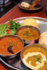 Indian cuisine: curry lunch plate (oyster and eggplant curry, chicken keema curry, dal curry, cheese kulcha, rice and salad)