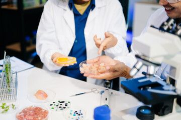 Food scientists in lab coats, testing samples, and analyzing food safety and quality in a modern laboratory