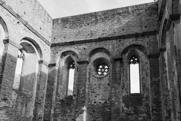 A view of the interior of a ruined building in Ireland, with windows and arches framing a view of...