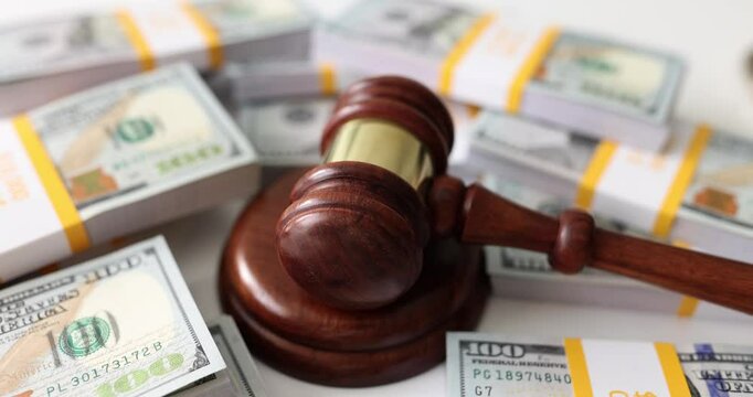 Judge wooden gavel on many dollar bills. Bribery and financial crimes