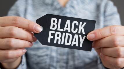 Hands of a person holding a black label with the word black friday, concept of promotion and sale.