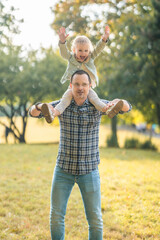 Young father and cute little daughter having fun together in autumn park at sunset light of Prague,...