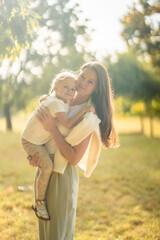 Fototapeta premium Mother and little daughter playing together in autumn park in Prague, Europe
