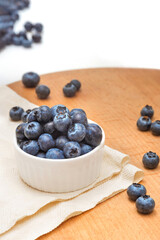 Bowl of blueberries on a wooden tray. Wild berries. Healthy eating