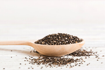 Wooden spoon and chia seeds on colored background, top view. Healthy Salvia hispanica Healthy superfood