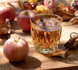 Glass of apple cider outdoors on wooden table