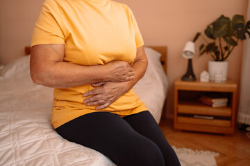 Abdominal pain in elder senior mature aging woman with stomachache illness from stomach cancer,...