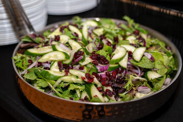 Fresh greens and cucumbers salad at an event 