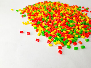Various colors of masterbatch granules on a white background, polymer carriers of color pigments in...