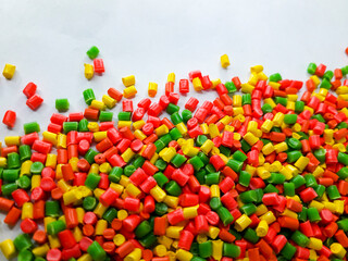 Various colors of masterbatch granules on a white background, polymer carriers of color pigments in...