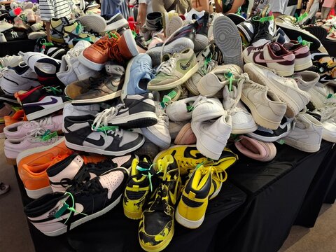 A variety of second-hand shoes stacked together at a market.