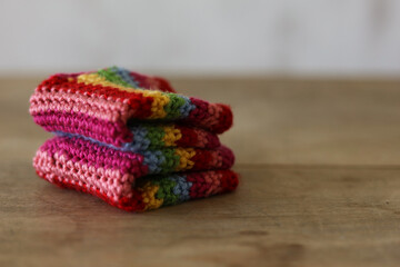 Obraz premium Colorful crochet gloves on a wooden background. Handmade. 