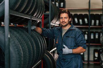 In professional uniform. Man is in the tire fitting car service