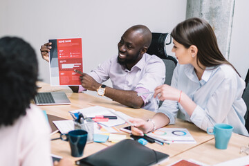 Positive confident professional people discussing business plan for company during conference meeting in office building, successful colleagues talking about productivity and motivation for employees