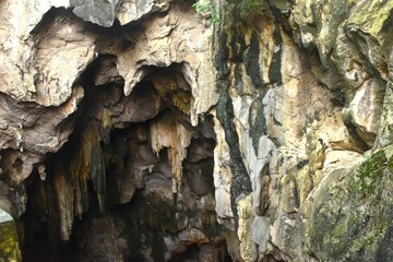 stalagmites and stalactites with sunlight through cave hole in Khao Luang cave travel location on Thailand