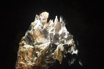 Fototapeta premium stalagmites and stalactites with sunlight through cave hole in Khao Luang cave travel location on Thailand