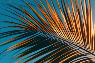 Obraz premium Golden Palm Leaf Against a Blue Sky