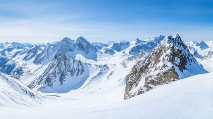 A panoramic view of snow-capped mountains with a bright blue sky. The mountains are covered in snow and the sky is clear and blue. The scene is peaceful and serene.