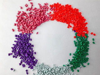 Various colors of masterbatch granules form a circular frame, a color pigment carrier polymer in...
