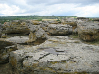 Rock formations in a natural landscape under cloudy skies during the daytime