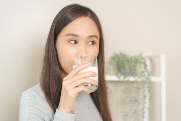 Health care asian young woman, girl drinking a glass of white fresh, dairy soy milk for calcium, vitamin wholesome good nutrition in the morning, isolated on white background product healthy people.