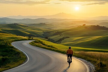 Cyclist Riding on Winding Road Through Tuscan Hills at Sunset - Photo