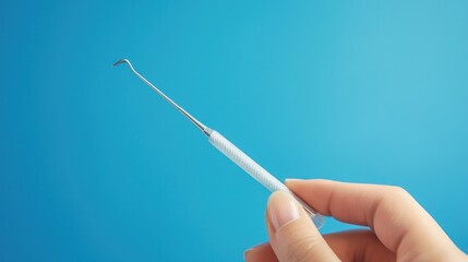 A hand holding a dental instrument ready for use.