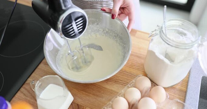 Kneading dough according to recipe using an electric mixer in kitchen