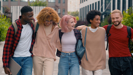 Happy smiling multiracial students diverse multiethnic diversity friends walking in city university college campus outdoors studying hugging together talking communicating laughing walk to lesson