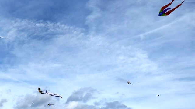 viele farbenfrohe Winddrachen tanzen im leichten Wind an herstlichem leicht bew&ouml;lktem Himmel, Drachensteigen, Windvogel, Drachenflugger&auml;t, bunt, Drachen basteln