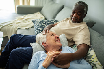 Obraz premium Happy senior couple relaxing together on couch at home
