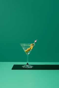 C&oacute;ctel de Martini seco con aceitunas sobre fondo verde