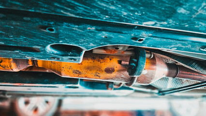 Close-up of old exhaust resonator on exhaust system of vehicle