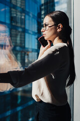 Young businesswoman speaking on phone in office