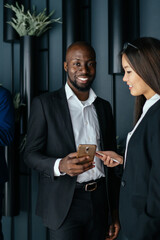 Group of modern diverse employees with smartphones