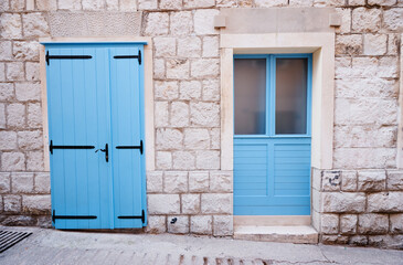 Stone old building with blue wooden vintage window and door