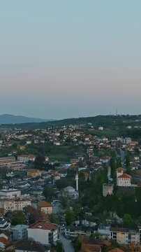 Vertical Screen: Aerial view of Gradacac in Bosnia at sunset during Ramadan, with fireworks and cannon firing to signal the end of fasting. Concept of tradition, religious celebration