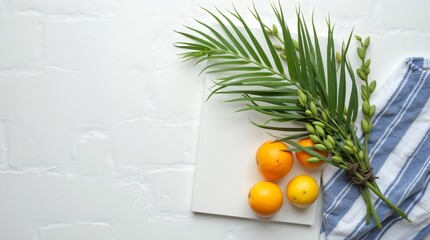 Green willow branches, palm branches, citrus fruits on a white wooden background. The concept of the Sukkot holiday. A copy space. top view