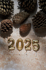 Decorative natural arrangement with golden candles marking the arrival of 2025