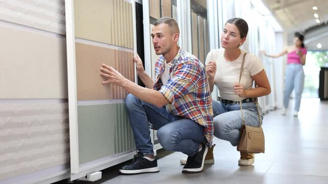 Construction store - young married couple chooses ceramic flooring. High quality 4k footage