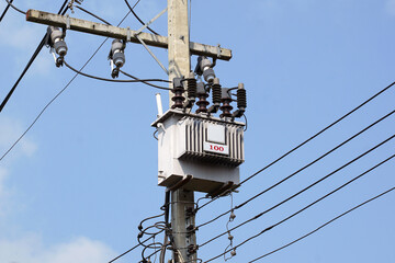 Power transformer installed on electric pole on daytime sky background. Soft and selective focus.